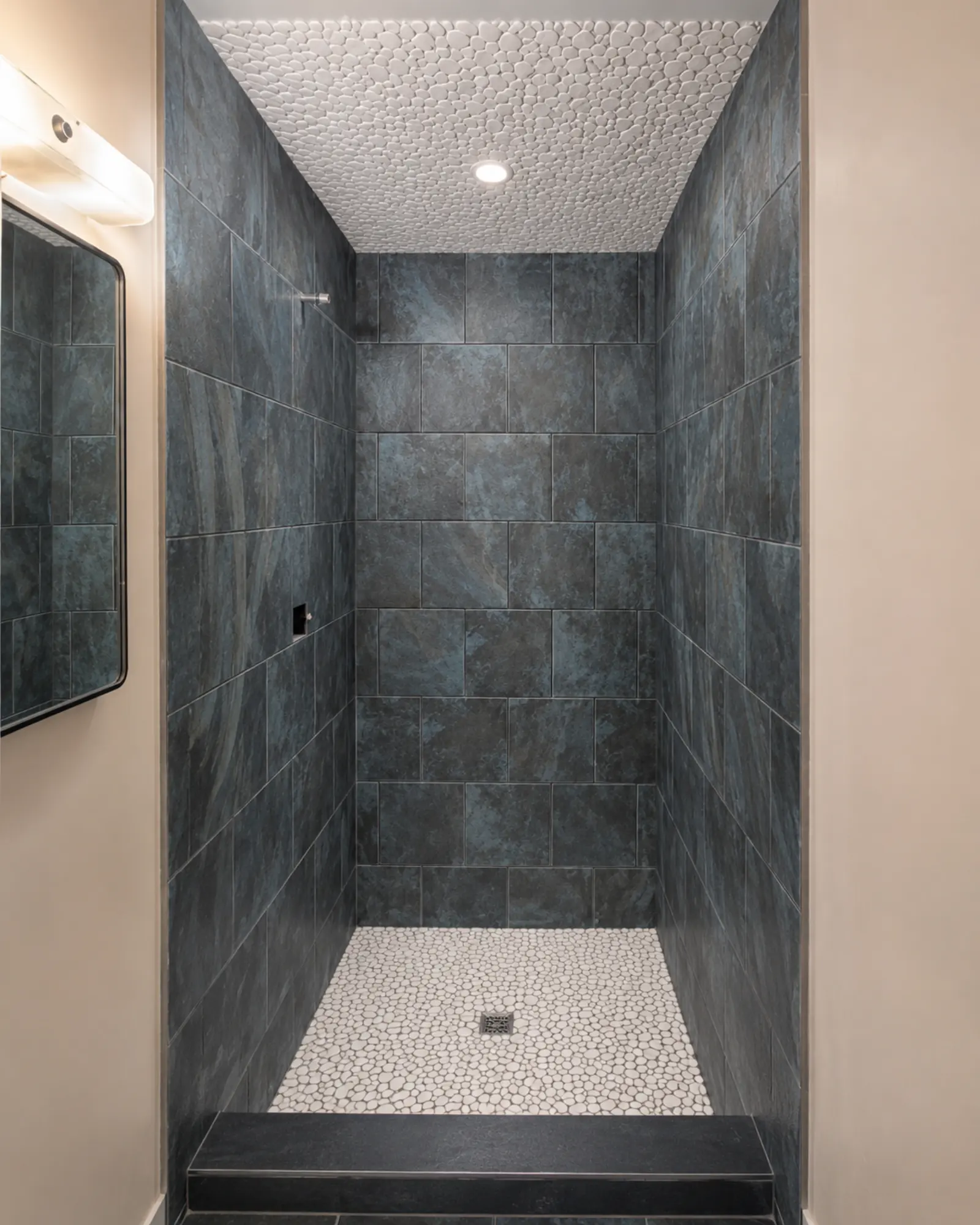 Modern walk-in shower with pebble accents by Almog Construction in Redmond, Oregon.