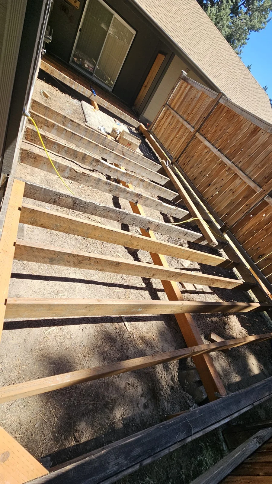 Back deck with exposed wood joists beside a wood fence in Bend, Oregon