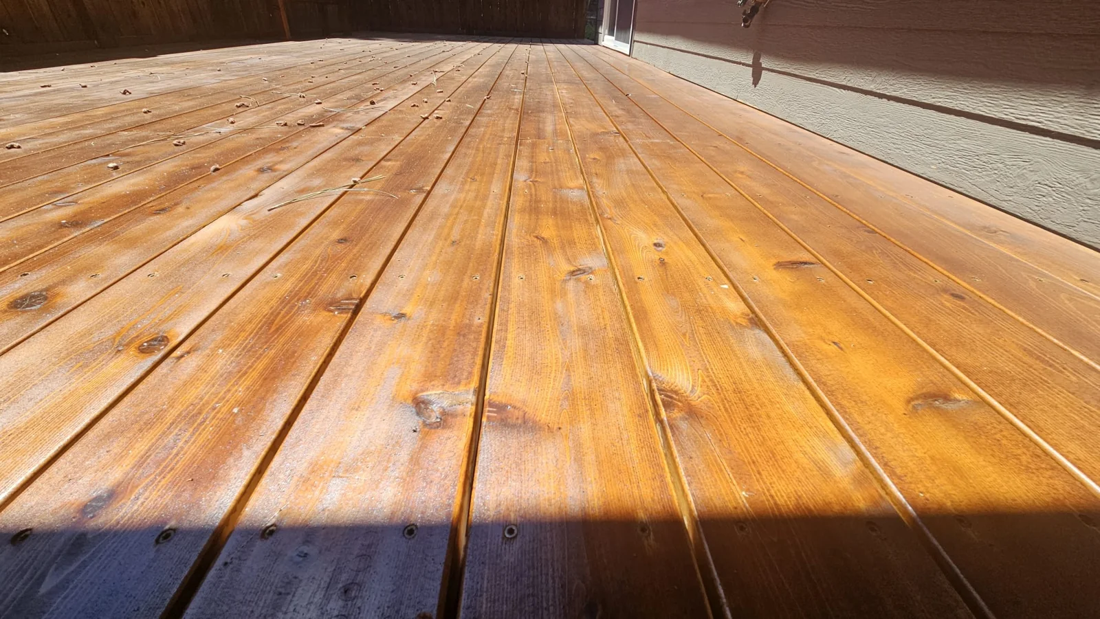 Close view of stained cedar deck boards beside house siding in Bend, Oregon