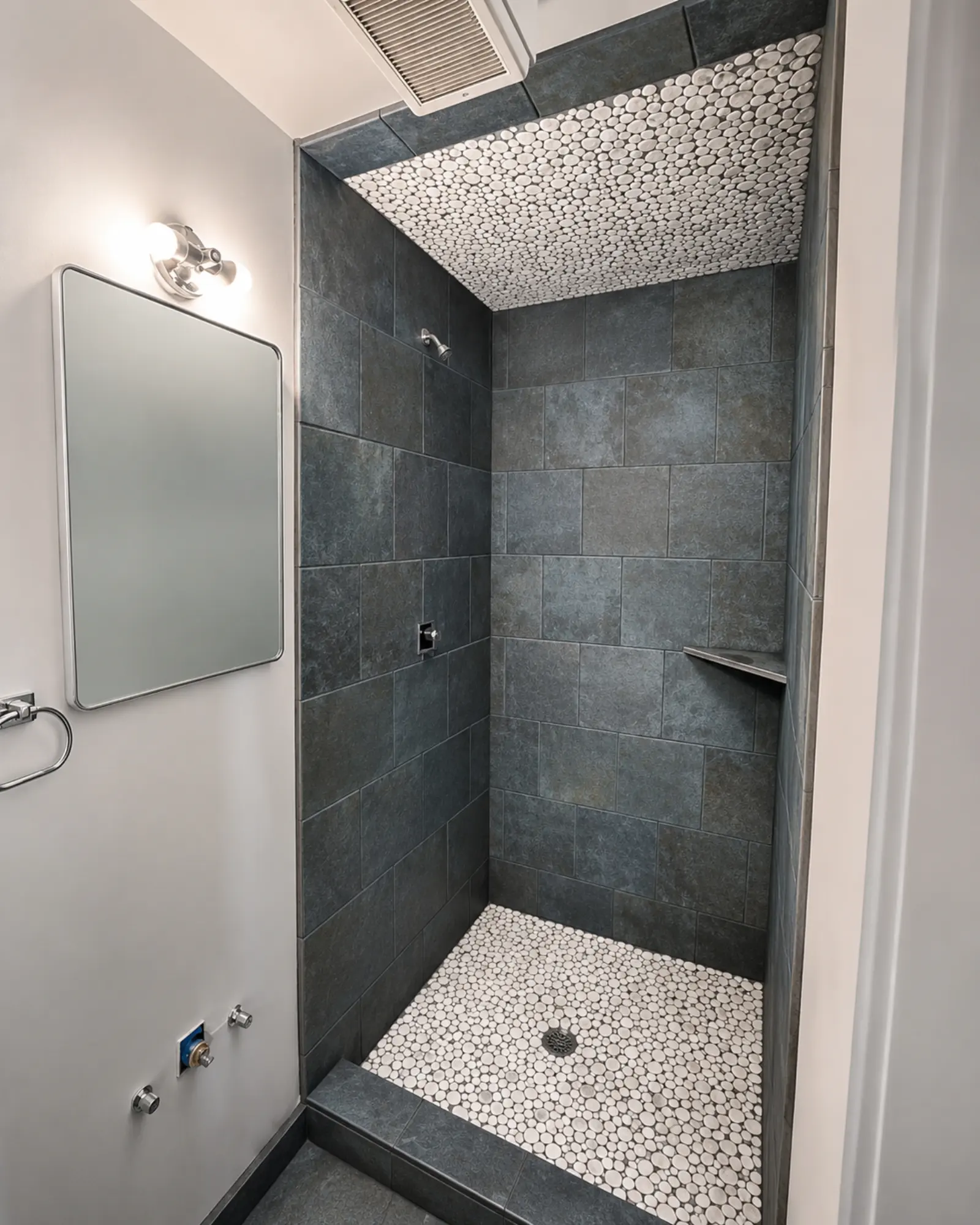 Compact modern bathroom with pebble accents remodeled by Almog Construction.