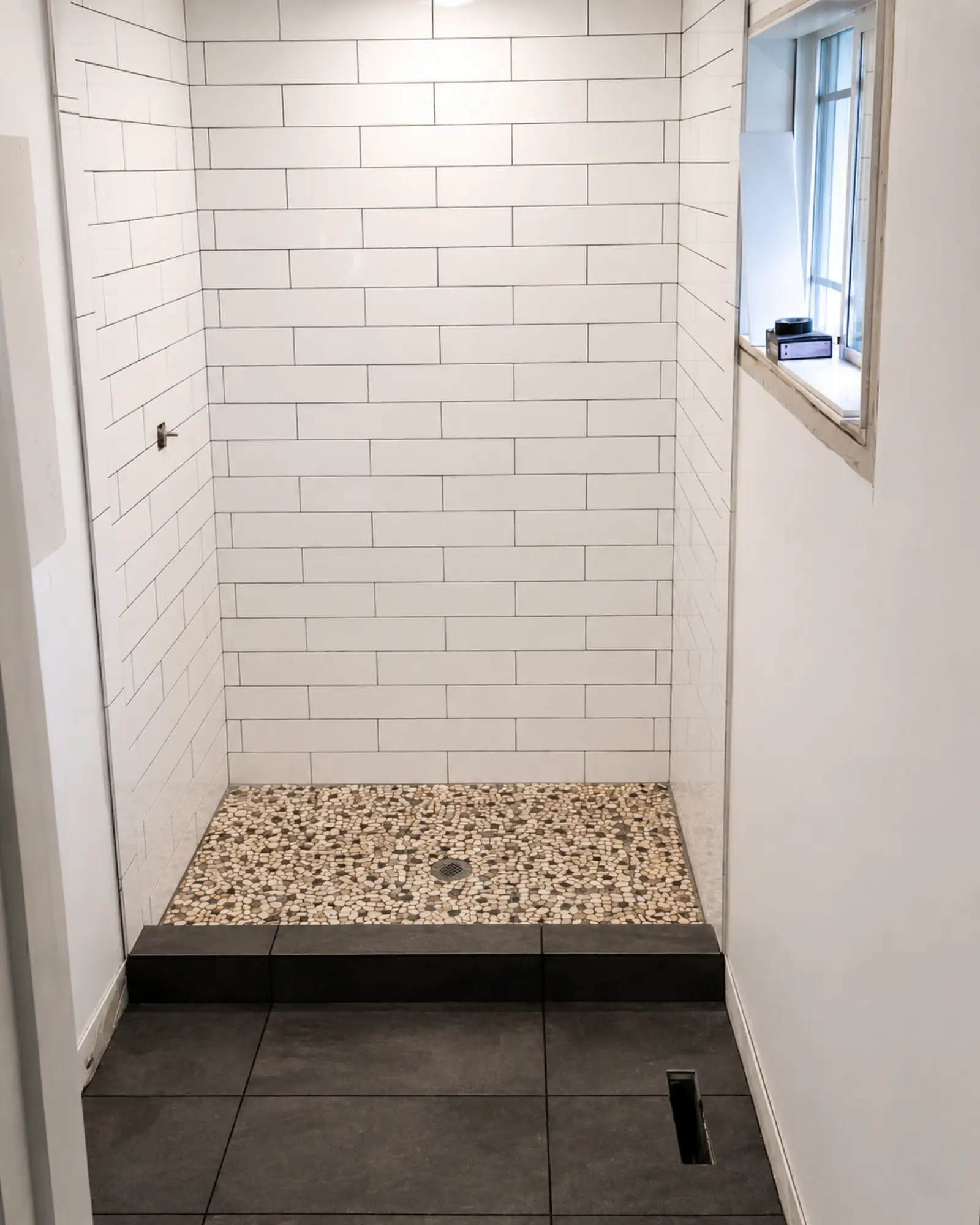 Modern minimalist bathroom with pebble floor by Almog Construction in Bend, Oregon.